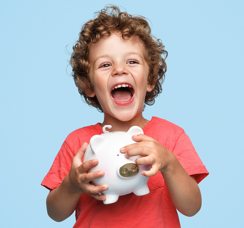 young boy laughing and clutching his piggy bank