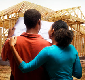 a man and woman looking at their home being built