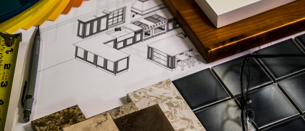 a drawing of a new kitchen lay out is surrounded by tile samples, counter top samples, a measuring tape, and, paint samples, and a pencil.